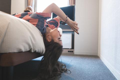 A girl lying on a bed and using her phone