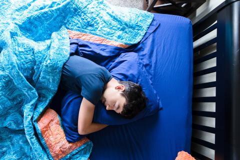 A young man sleeping in bed