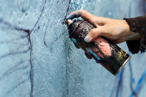 A person spraying paint onto a wall