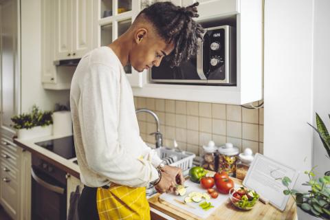 Young man cutting vegetables