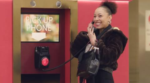 A woman holding a phone and smiling